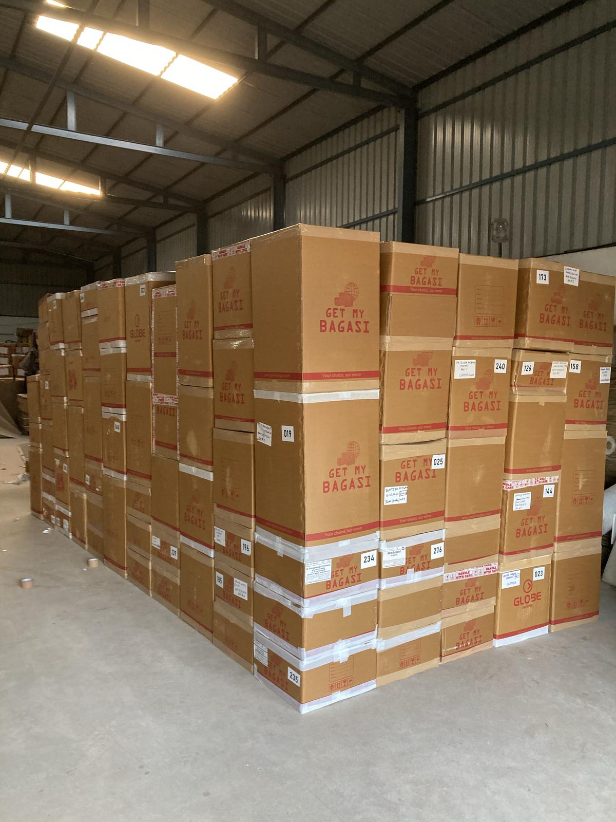 Warehouse stacked with branded Get My Bagasi cartons